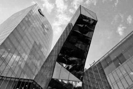 Foto en blanco y negro de un edificio diseñado con predominio del cristal
