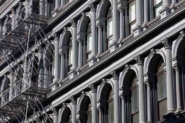 Fotografía en blanco y negro de ventanas y escalera de incendios de un edificio de Nueva York