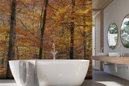 Cuarto de baño con un vinilo de un bosque junto a la bañera