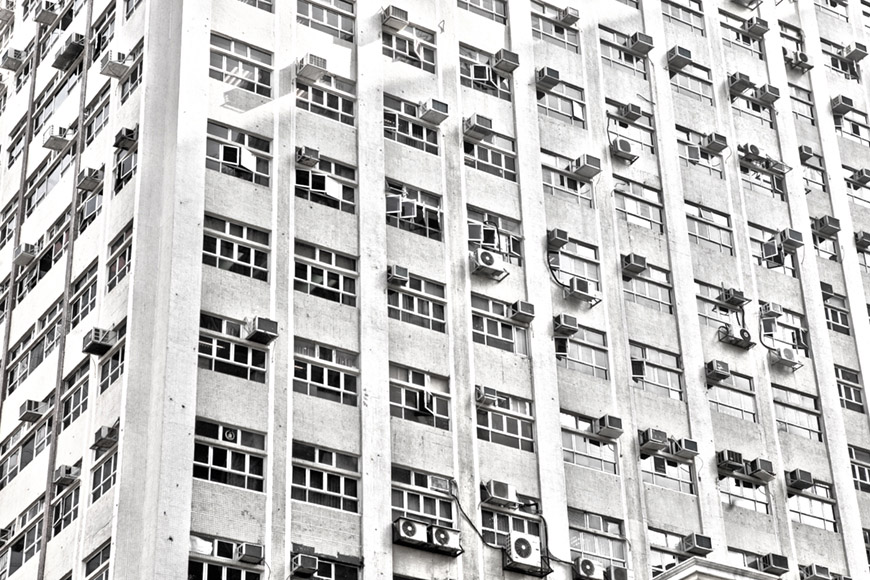 Foto decorativa que muestra una fachada con ventanas y aires acondicionados en Hong Kong
