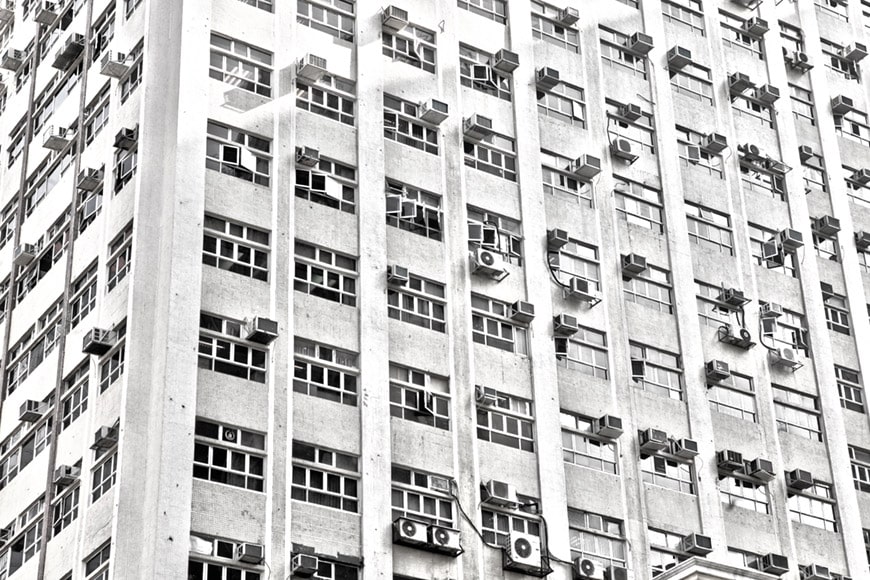 Foto decorativa que muestra una fachada con ventanas y aires acondicionados en Hong Kong