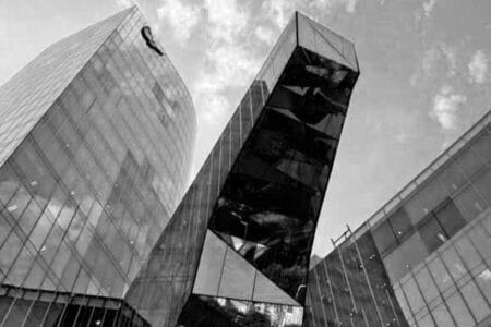 Foto en blanco y negro de un edificio diseñado con predominio del cristal