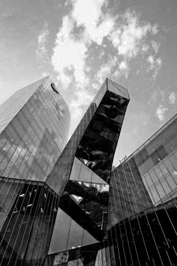 Foto en blanco y negro de un edificio diseñado con predominio del cristal