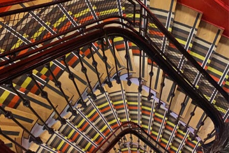 Fotografía tomada desde lo alto de una escalera colorista con mucha profundidad.
