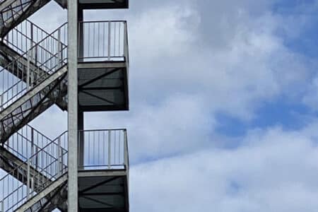 una escalera metálica protagoniza esta fotografía de cielo nublado.